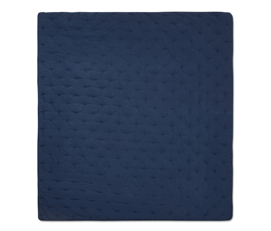 Detailansicht einer blauen Tagesdecke mit Steppmuster.