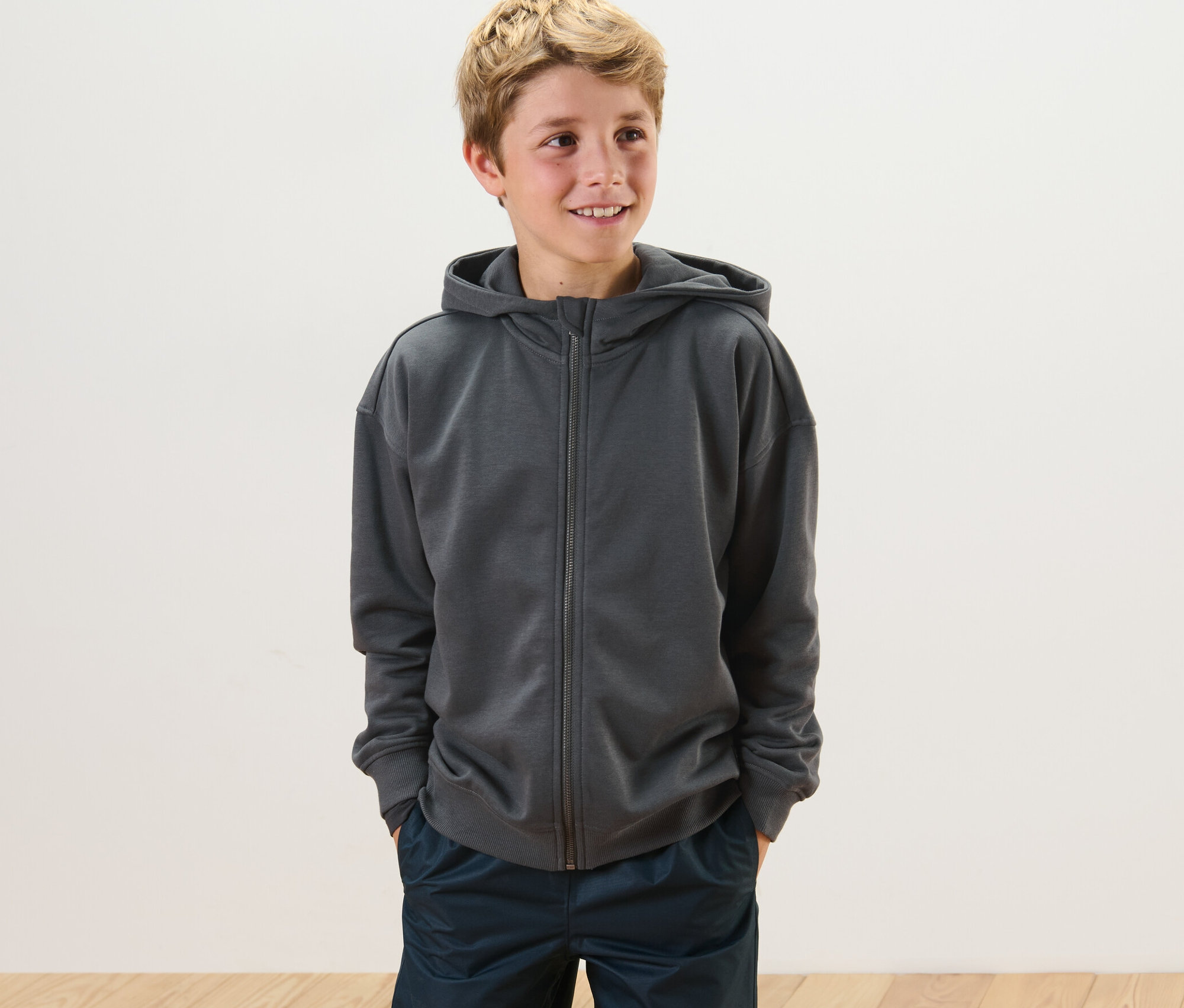 Junge trägt eine Kinder-Sweatjacke mit angerauter Innenseite.