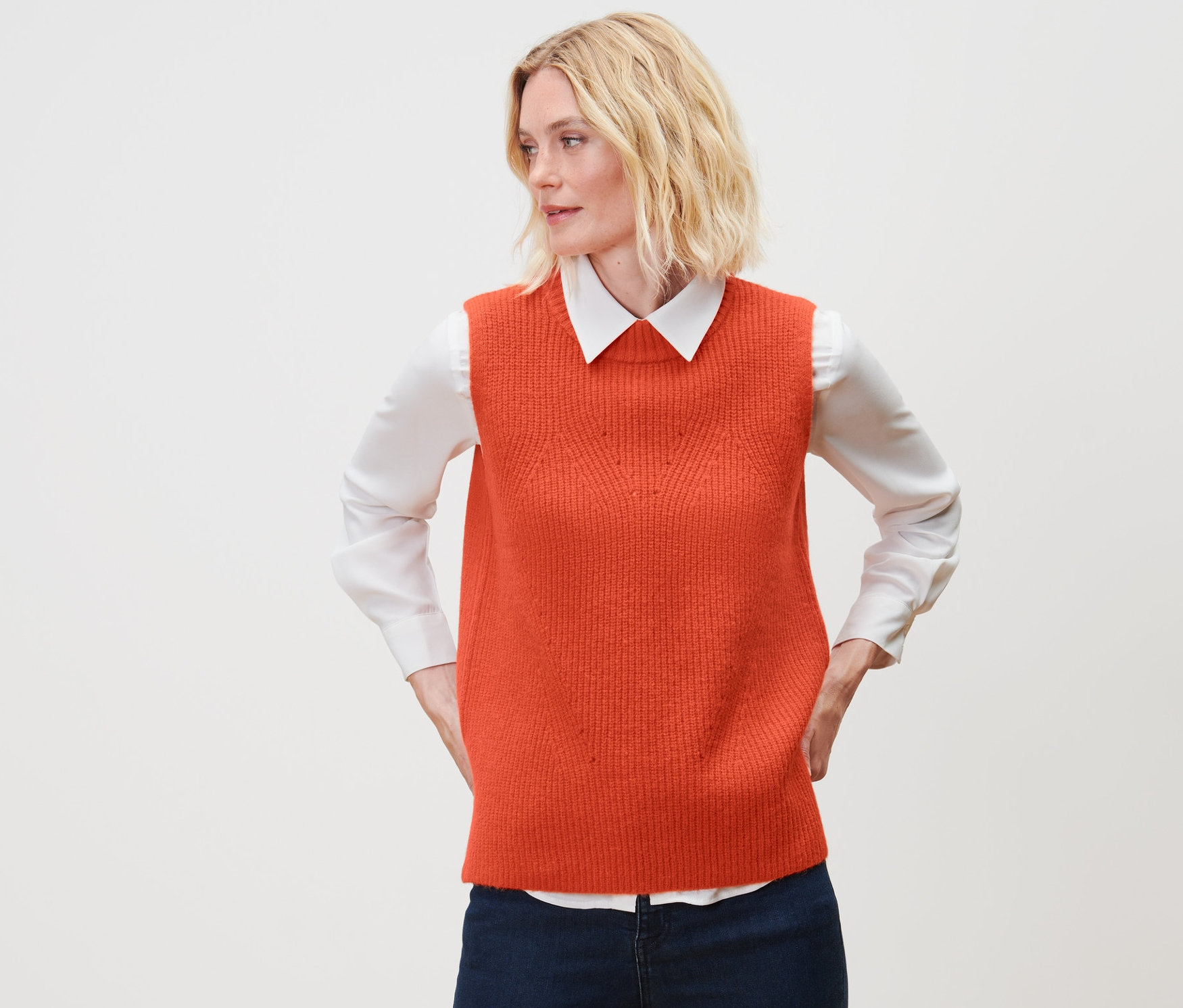 Frau trägt einen orangefarbenen Strick-Pullunder.