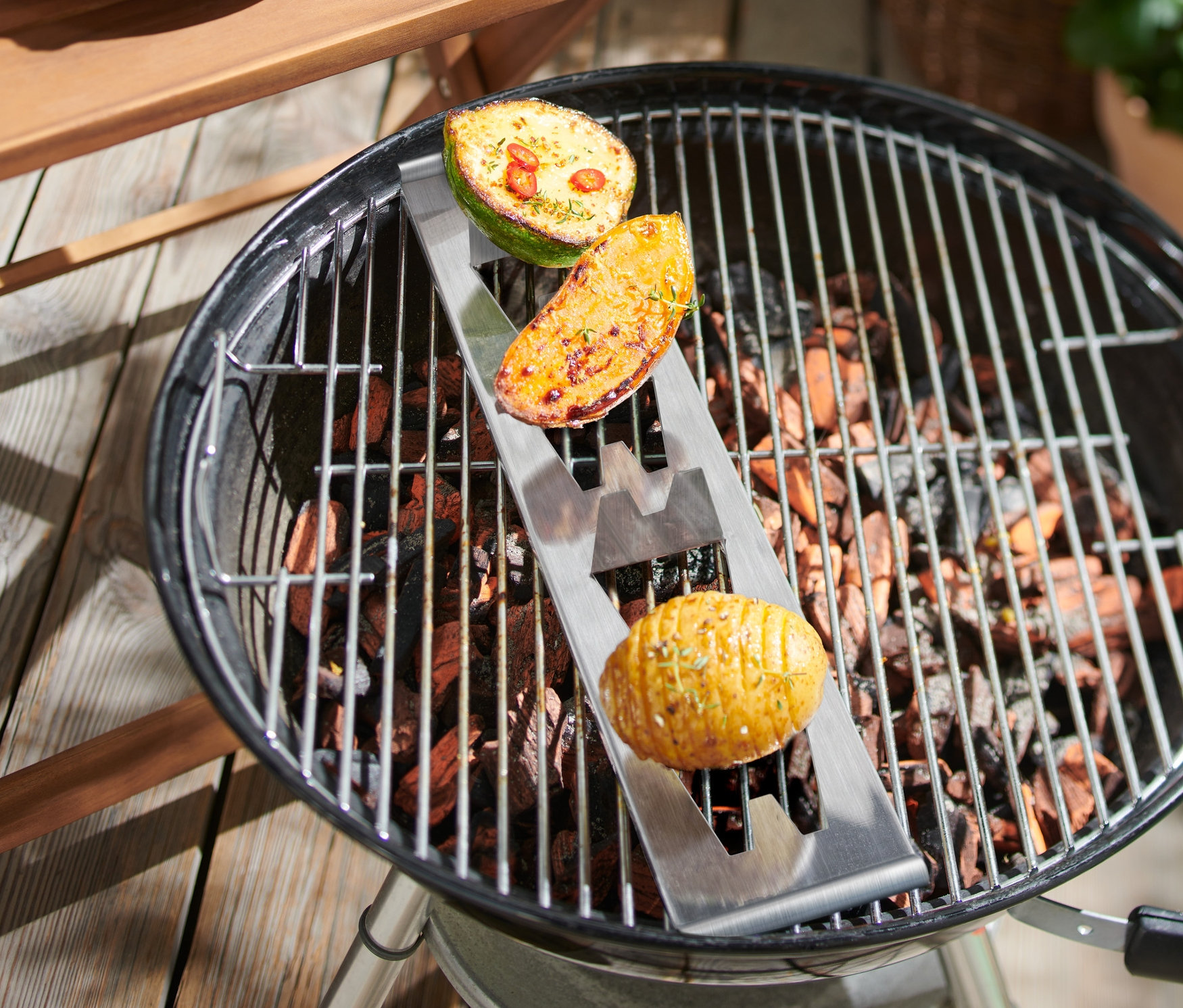 Kartoffeln im Kartoffelhalter auf Grill.
