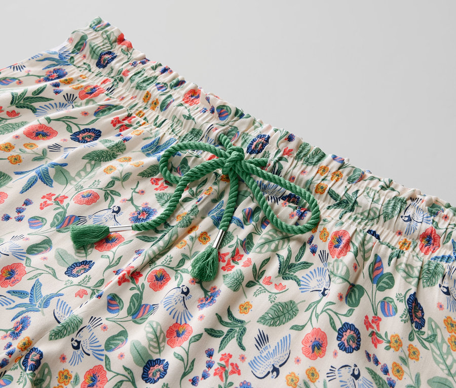 Detailansicht eines Shorty-Pyjama-Sets mit Blumenmuster und grünem Kordelzug.