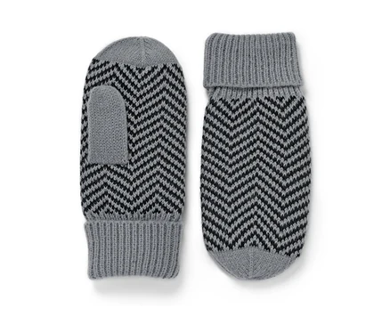 Zwei gestrickte Fäustlinge mit grauem und schwarzem Zickzackmuster.
