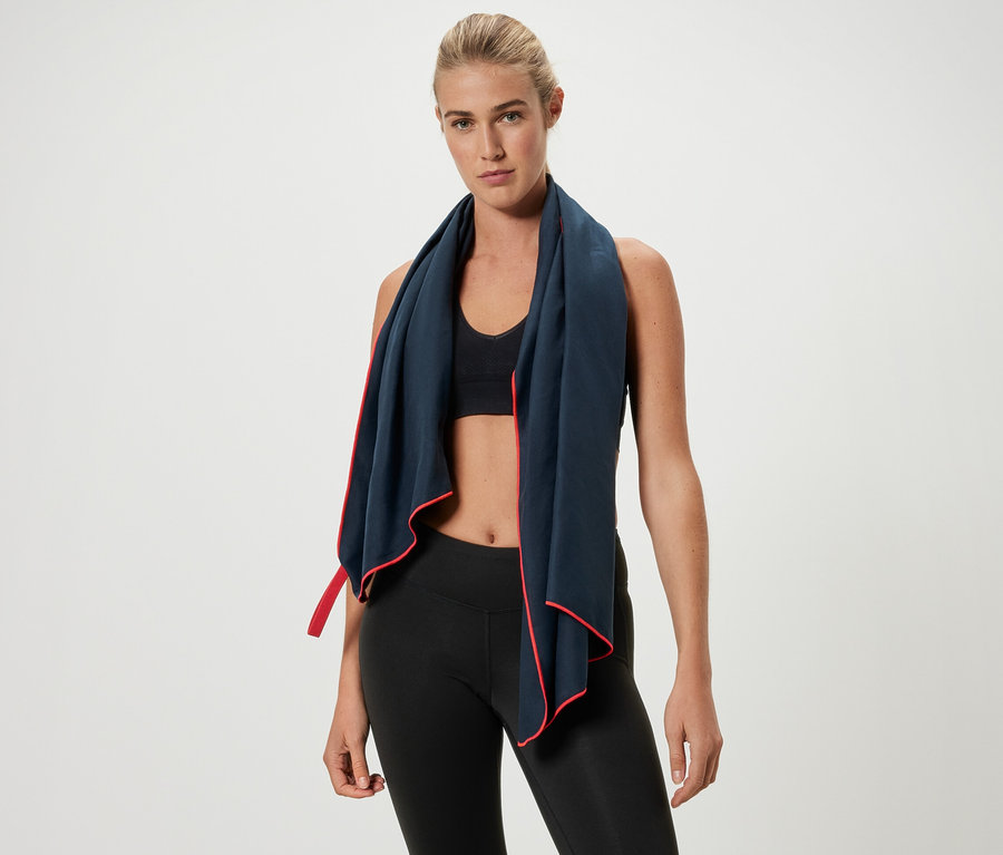 Blonde Frau trägt ein Sporttuch mit roter Bordüre um den Hals.