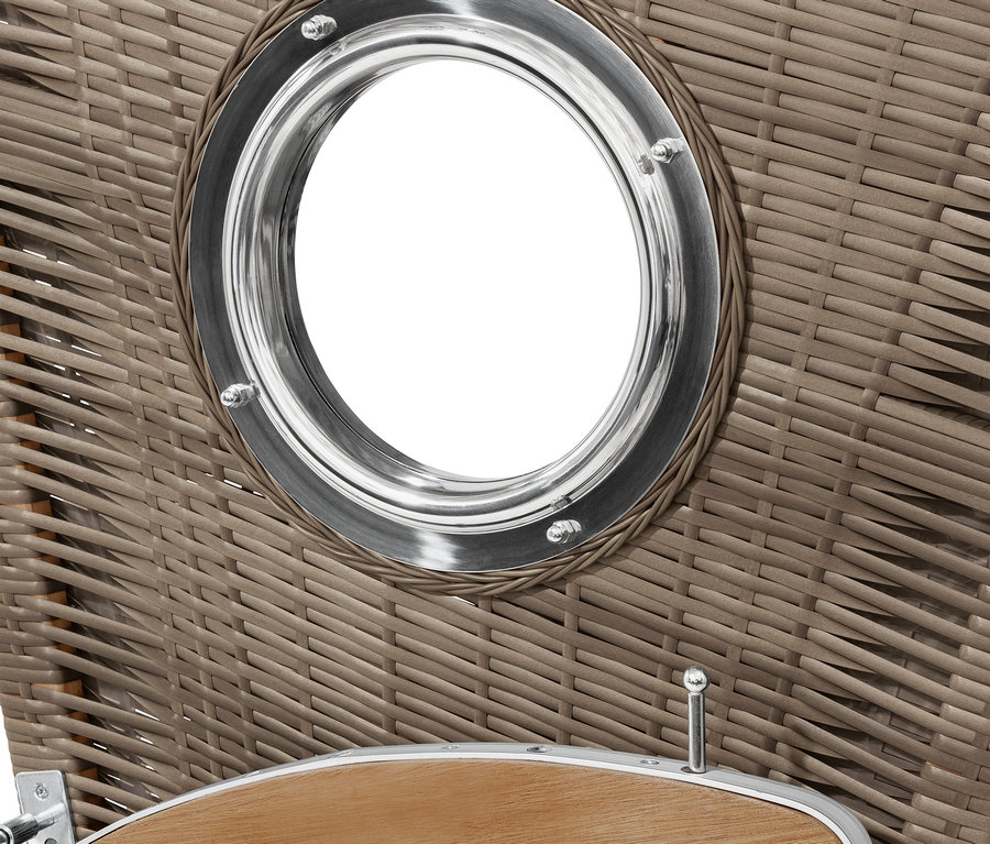 Detail eines geflochtenen Strandkorbs mit rundem Fenster mit Metallrahmen.