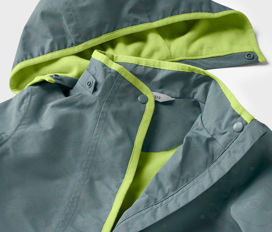 Detailansicht einer Kinder-Thermo-Regenjacke mit reflektierenden Elementen, graue Jacke mit lindgrünem Futter und Besatz.