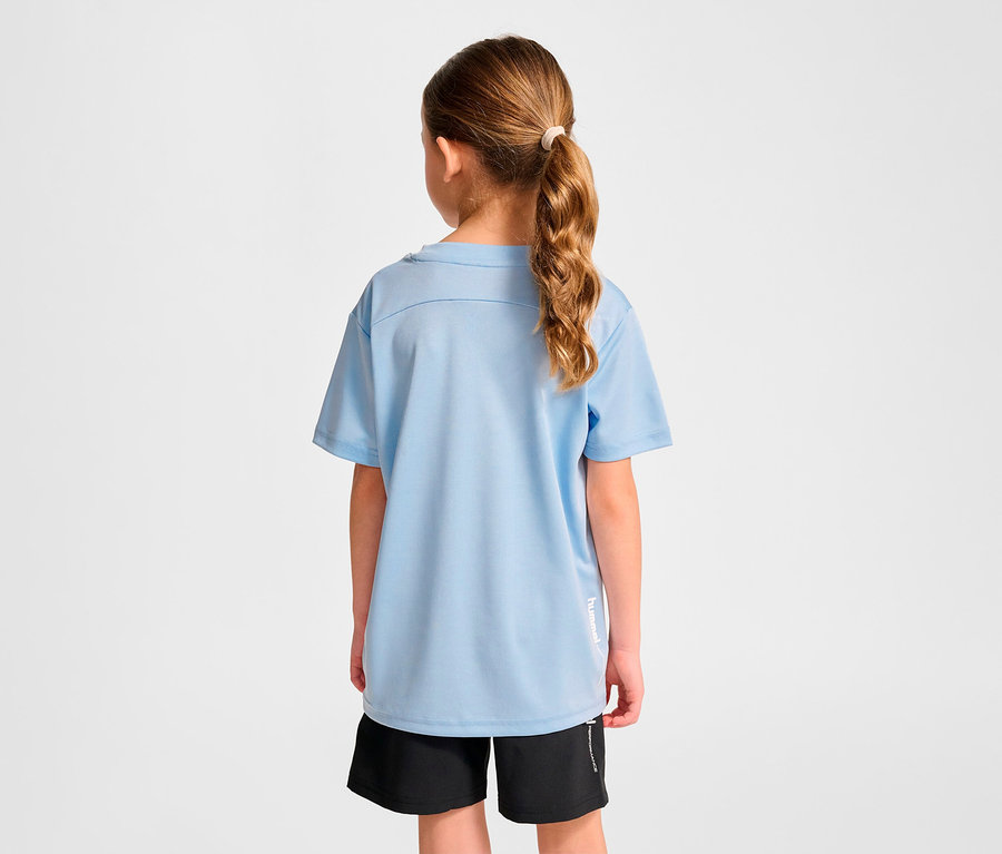 Mädchen trägt ein hellblaues HUMMEL HMLJR pulse Training-T-Shirt und schwarze Shorts, mit dem Rücken zur Kamera.
