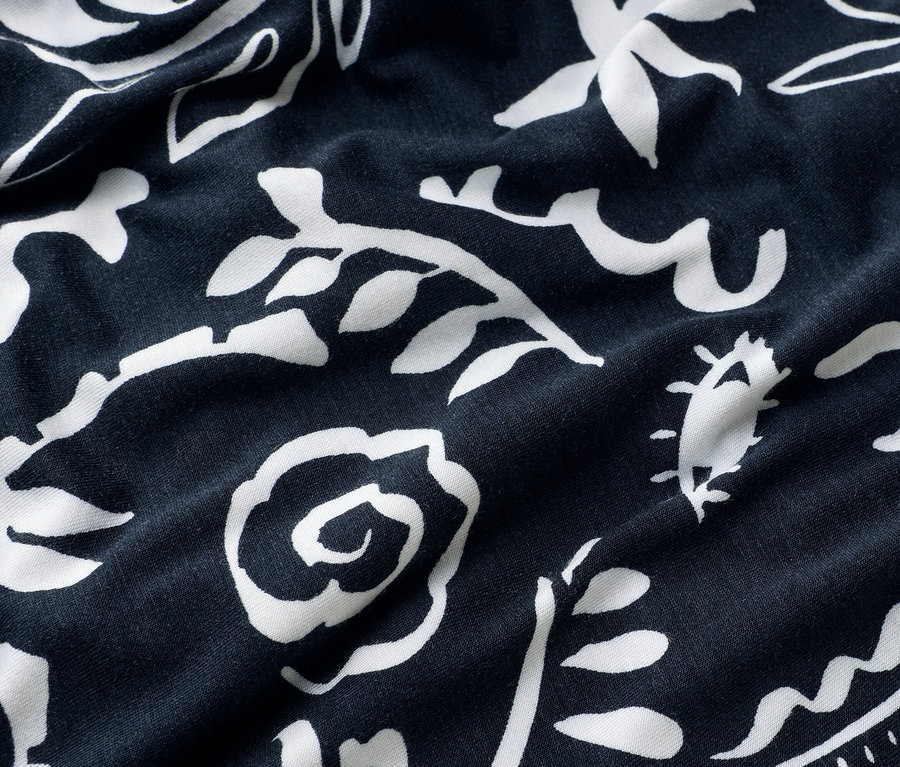 Nahaufnahme von marineblauem Stoff mit weißem Blumenmuster.