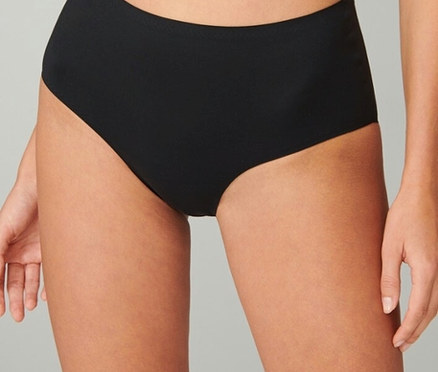 Nahaufnahme einer Frau, die eine schwarze, hoch taillierte Bikinihose trägt.