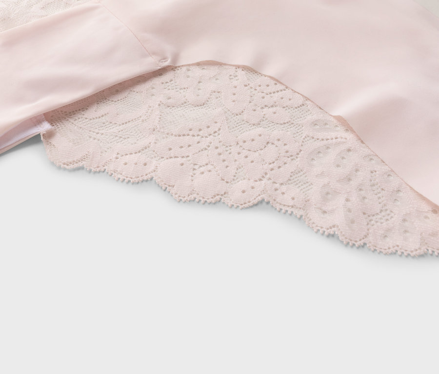 Nahaufnahme eines rosa Stoffes mit Spitzenbesatz.