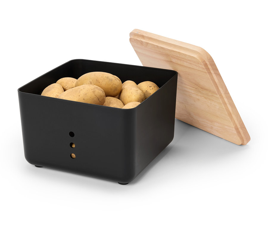 Eine schwarze Kartoffelbox ist mit Kartoffeln gefüllt, daneben liegt ein Holzdeckel.