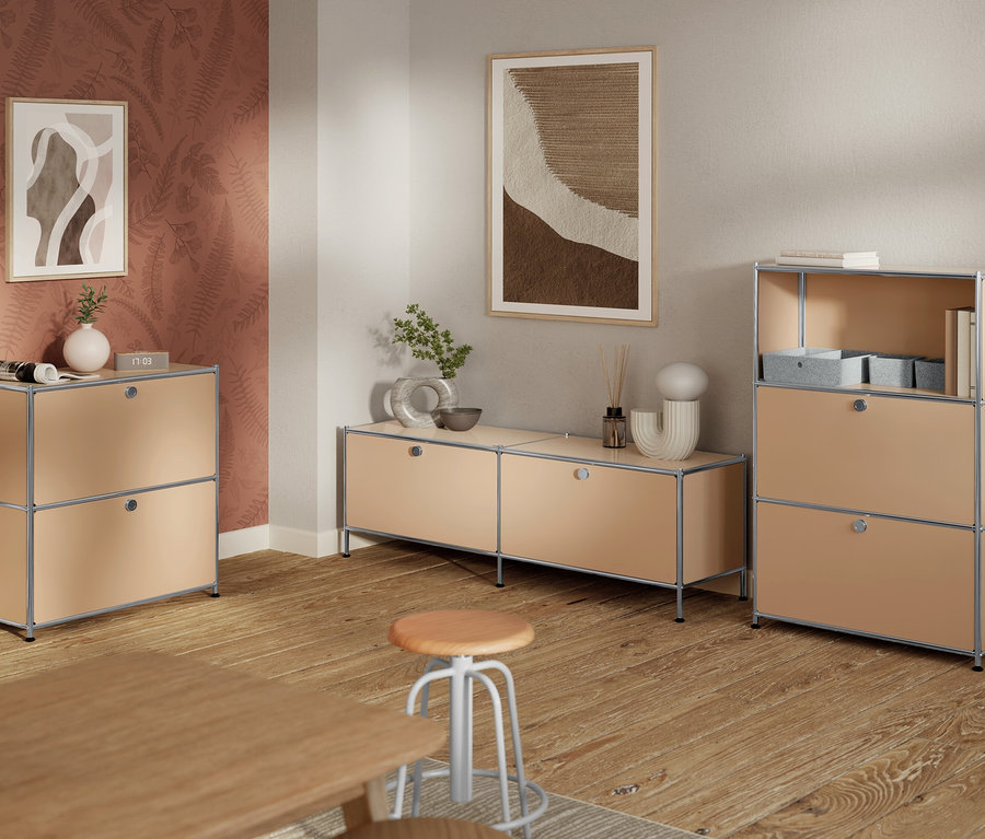 Wohnzimmer mit hellbraunen modularen Aufbewahrungseinheiten, hellbraunem Hocker, Holzboden und abstrakten Bildern an der Wand.