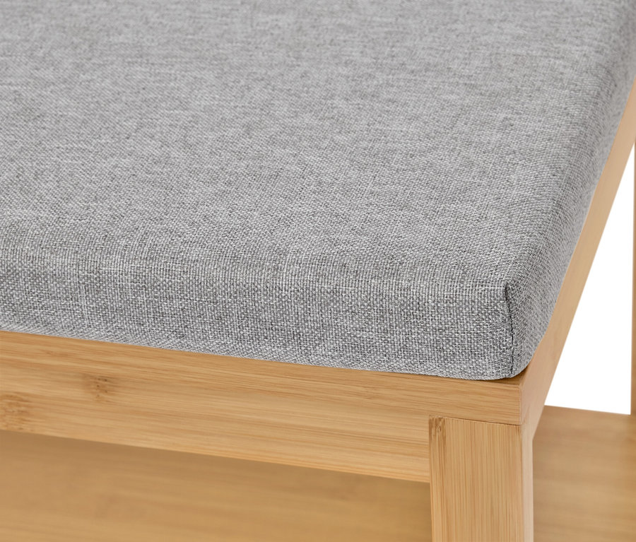 Nahaufnahme eines Hockers mit grauem Stoffbezug und hellem Holzgestell.
