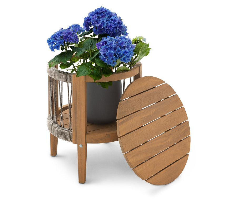 Blauer Hortensienbusch in einem grauen Topf auf einem zweistöckigen Beistelltisch aus Holz mit einer ovalen Tischplatte, die daneben steht.