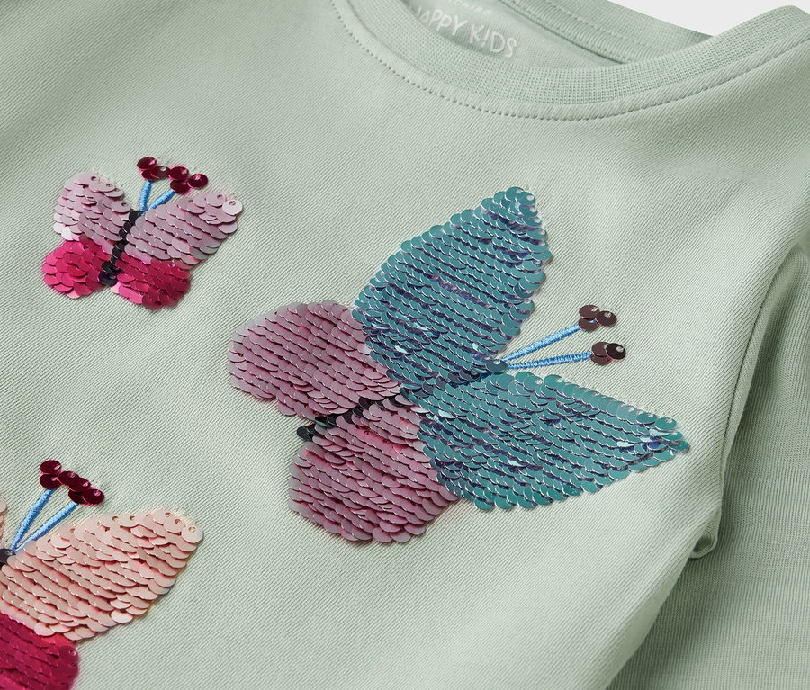 Hellgrünes Langarmshirt mit Pailletten-Schmetterlingen.