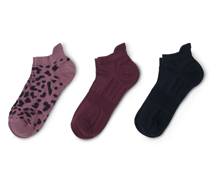 Drei kurze Socken liegen auf einem weißen Hintergrund, von links nach rechts: lila mit Leopardenmuster, weinrot und schwarz.