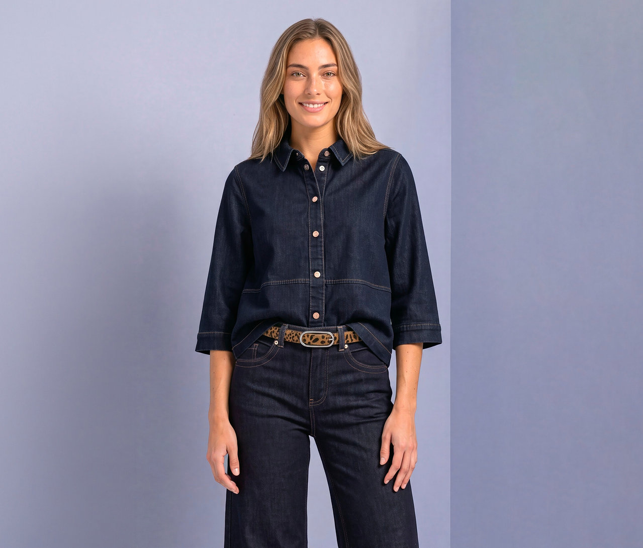 Lachende Frau trägt eine dunkelblaue Street One Hemdbluse mit 3/4-Ärmeln, dunkle Jeans und einen Gürtel mit Leopardenmuster.