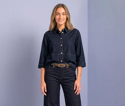 Lachende Frau trägt eine dunkelblaue Street One Hemdbluse mit 3/4-Ärmeln, dunkle Jeans und einen Gürtel mit Leopardenmuster.
