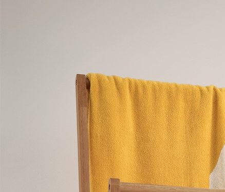 Ein gelb-weiß gestreiftes Jacquard-Badetuch und zwei beige-weiß gestreifte Handtücher hängen auf einem Klappbaren Kleiderständer. Darunter stehen 2 Aufbewahrungskörbe.