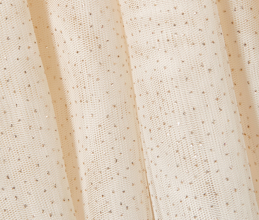 Detailaufnahme eines cremefarbenen Kleinkind-Tüllrocks mit feinen goldenen Punkten.