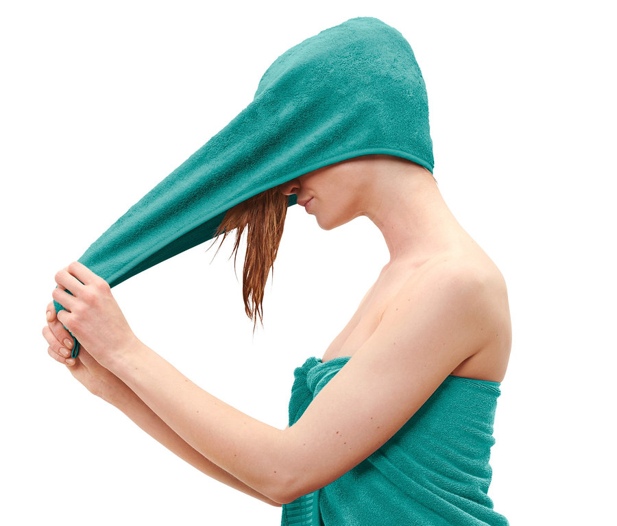 Frau setzt Turban-Handtuch in Aqua auf.