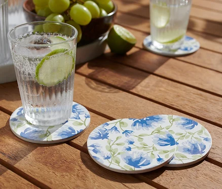 Ein Glas mit Getränk steht auf einem der 4 Getränkeuntersetzer auf einem Holztisch.