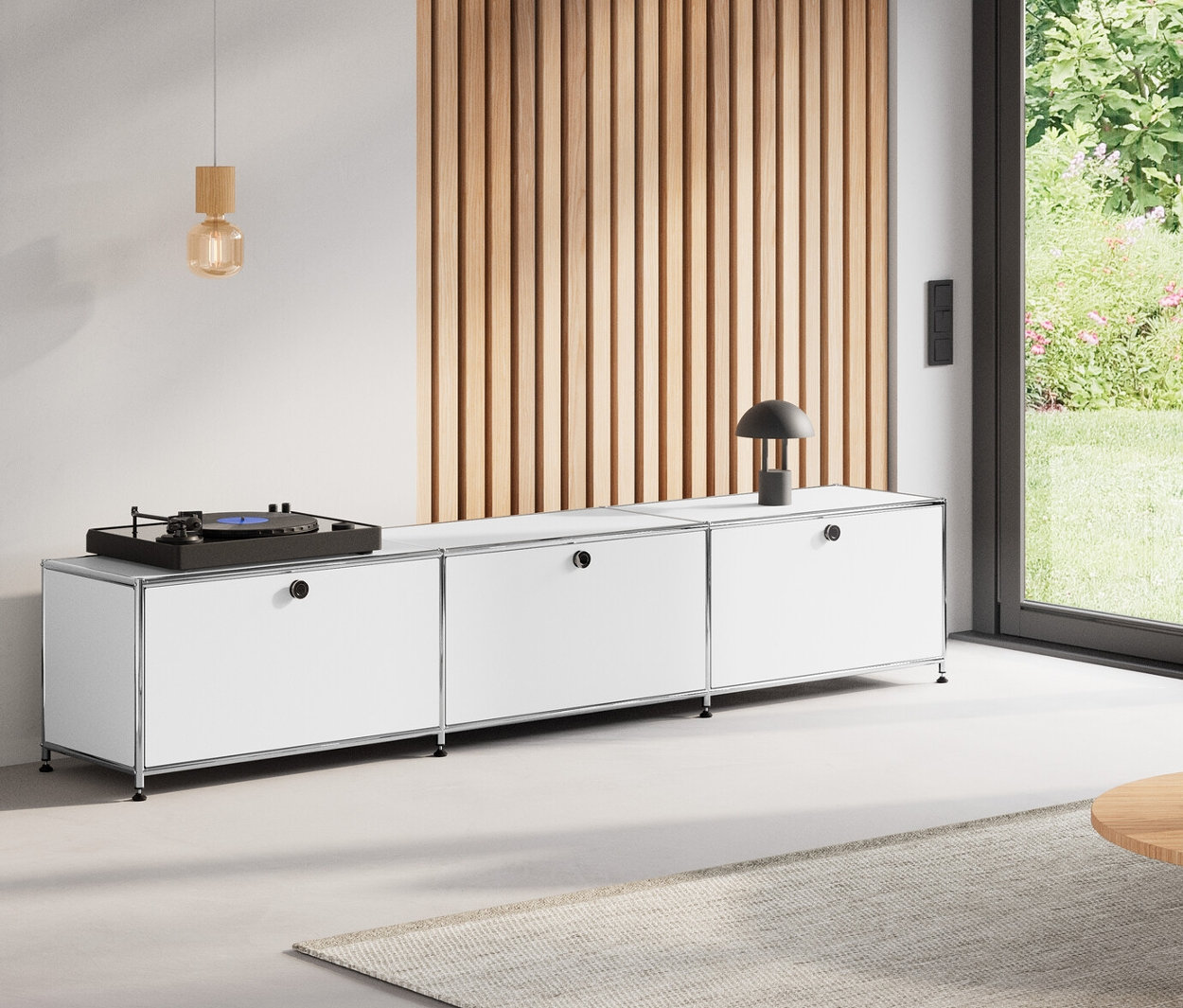 Wohnzimmer mit rundem Couchtisch, 80 cm, Lowboard Metall »CN3« mit 3 weißen Klappenfächern, Klappenergänzungs-Set Metall »CN3«, orange, und Hängeleuchte aus Holz.