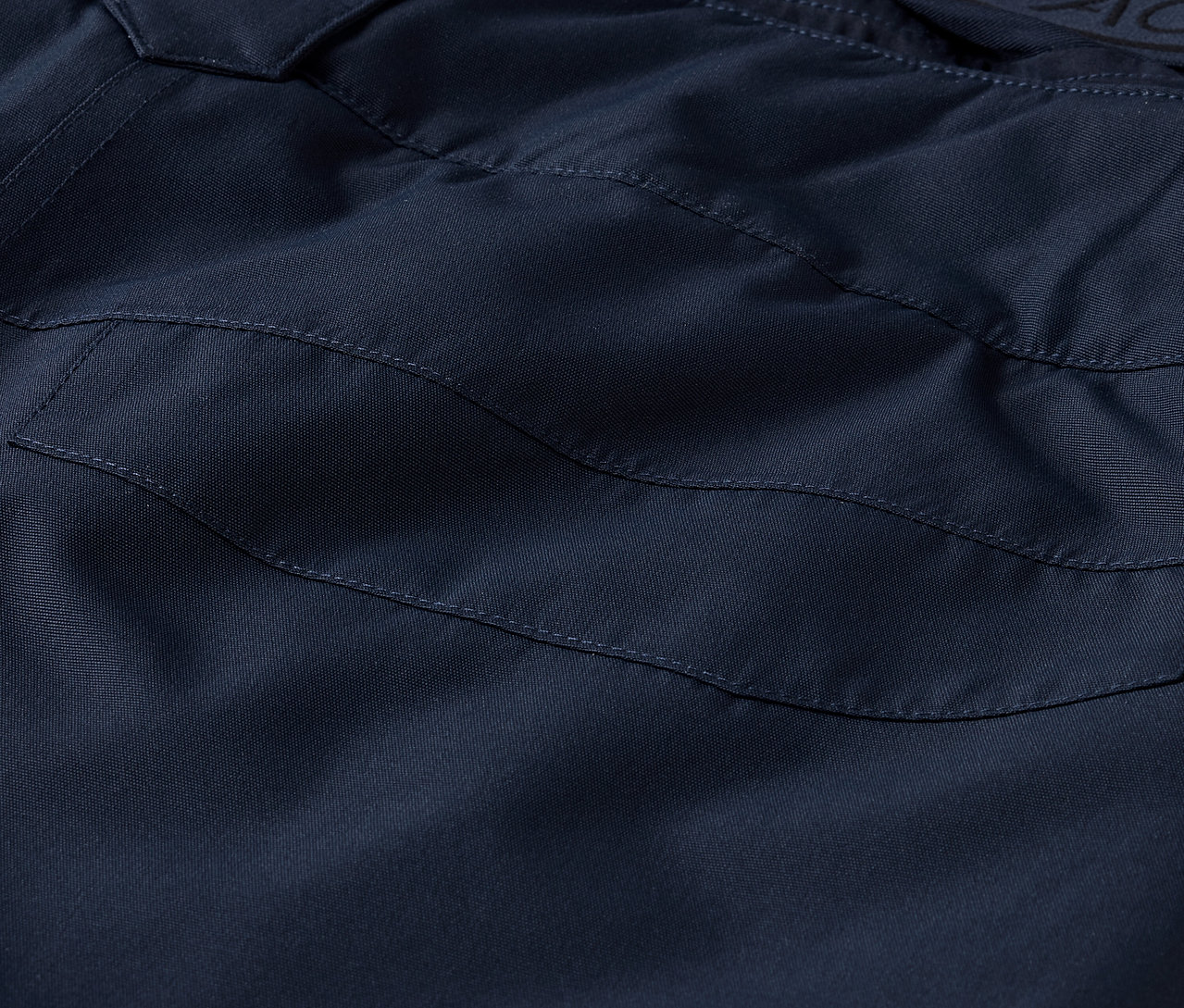 Detailaufnahme einer marineblauen Hose mit Tasche.