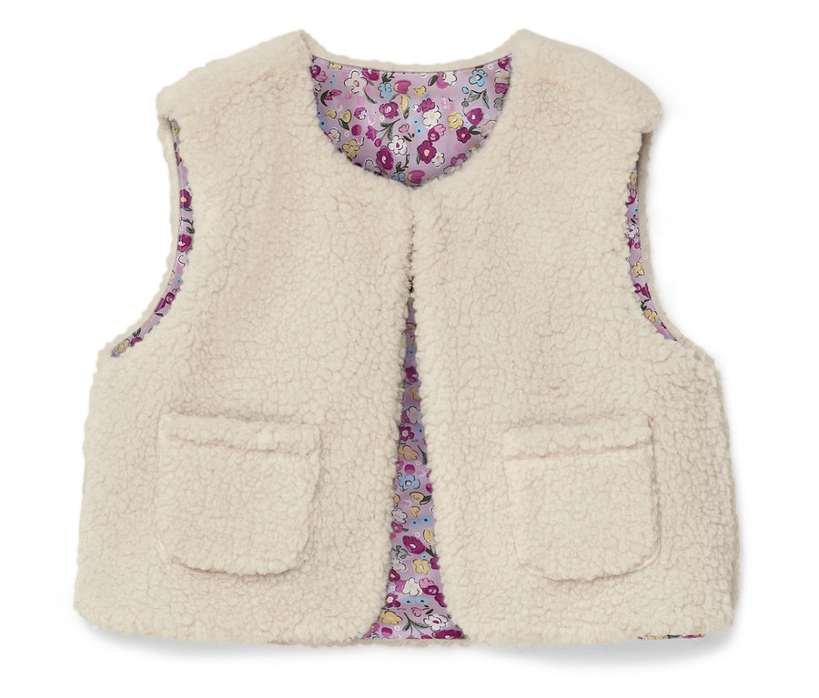 Eine ärmellose, flauschige, cremefarbene Weste mit zwei aufgesetzten Taschen und einem floralen Innenfutter.