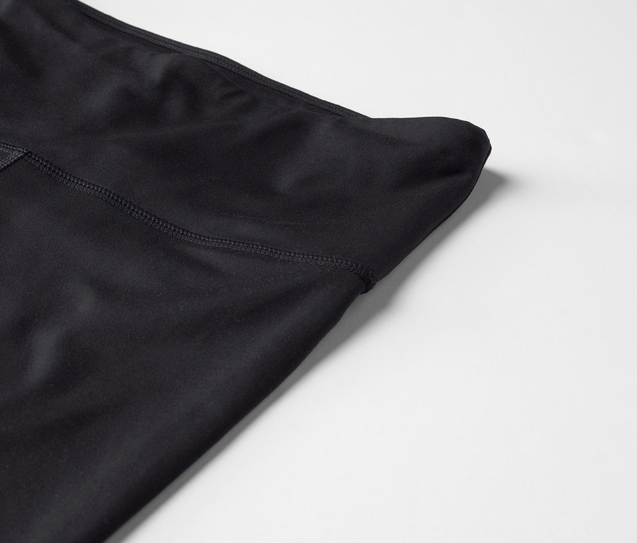 Detailaufnahme einer schwarzen High-Waist-Leggings auf einem weißen Hintergrund.