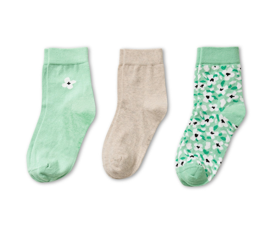Drei Paar Socken: ein Paar hellgrün mit weißer Blume, ein Paar beige und ein Paar hellgrün mit Blumenmuster.