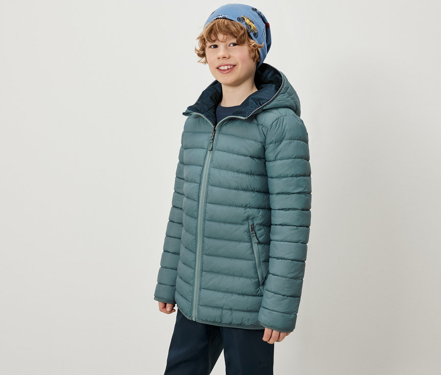 Junge trägt 2-in-1-Kinder-Softshell-und-Steppjacke und eine blaue Mütze.