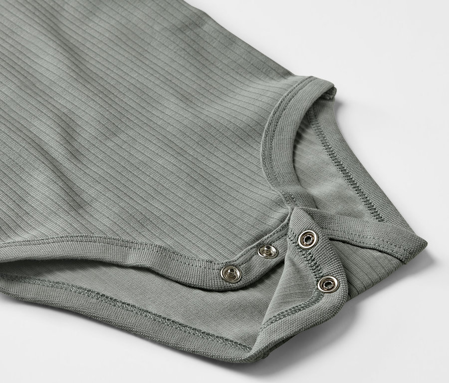Detailaufnahme eines grauen Baby-Ripp-Langarmbodys mit Druckknöpfen.
