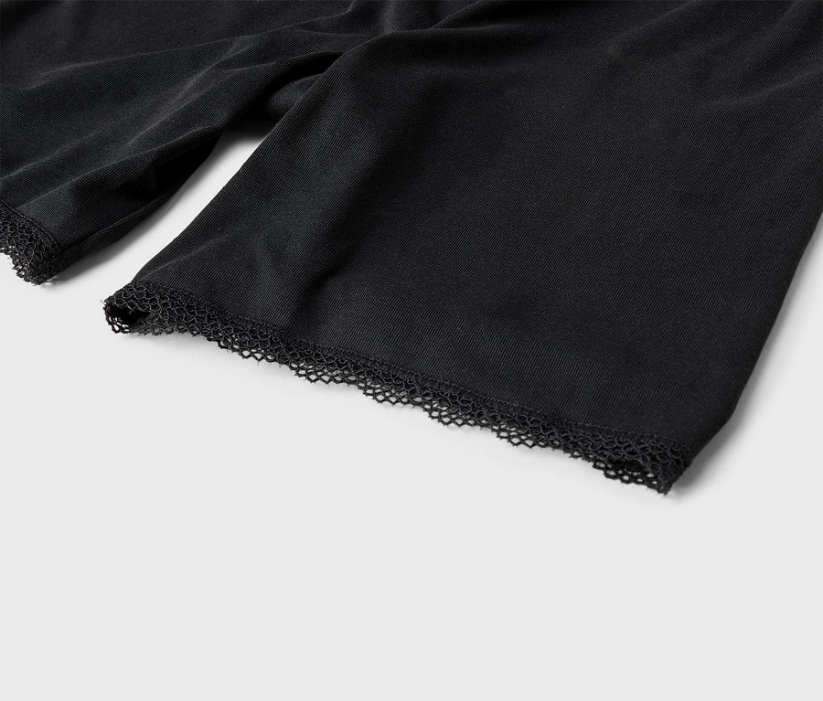 Nahaufnahme von Ärmeln eines schwarzen Stoffes mit Spitzenbesatz.