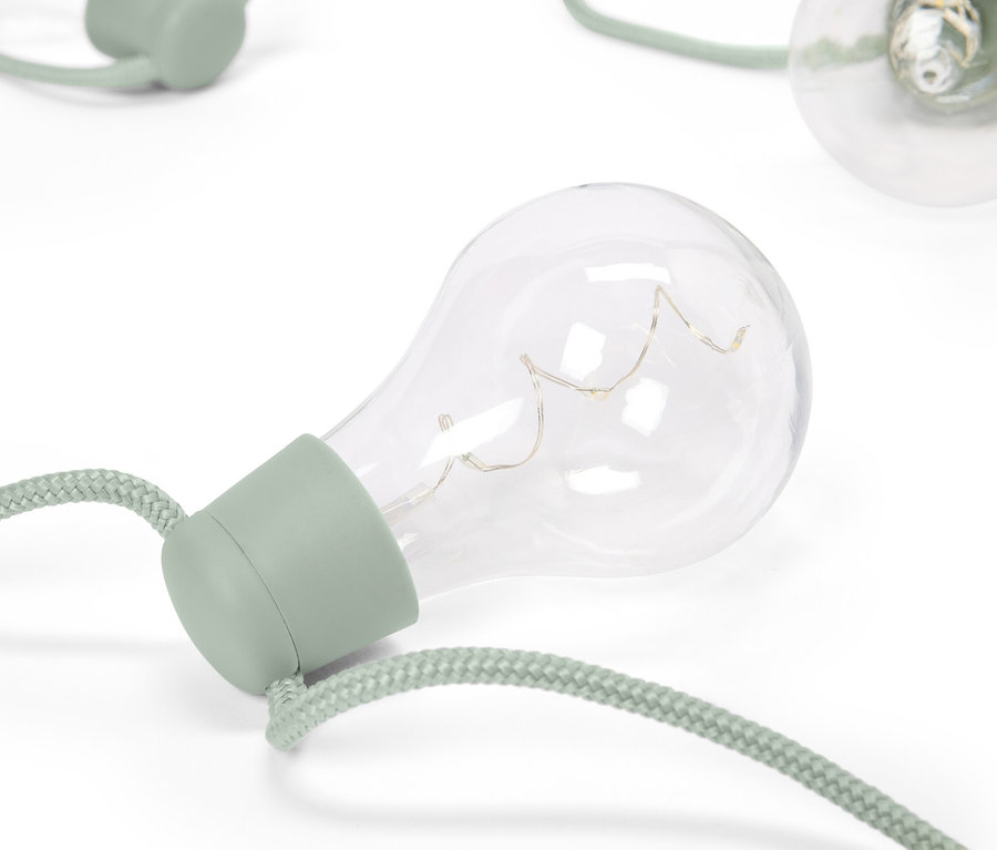 Nahaufnahme von dekorativen Glühbirnen mit grünen Fassungen und Seilschnüren auf einem weißen Hintergrund.