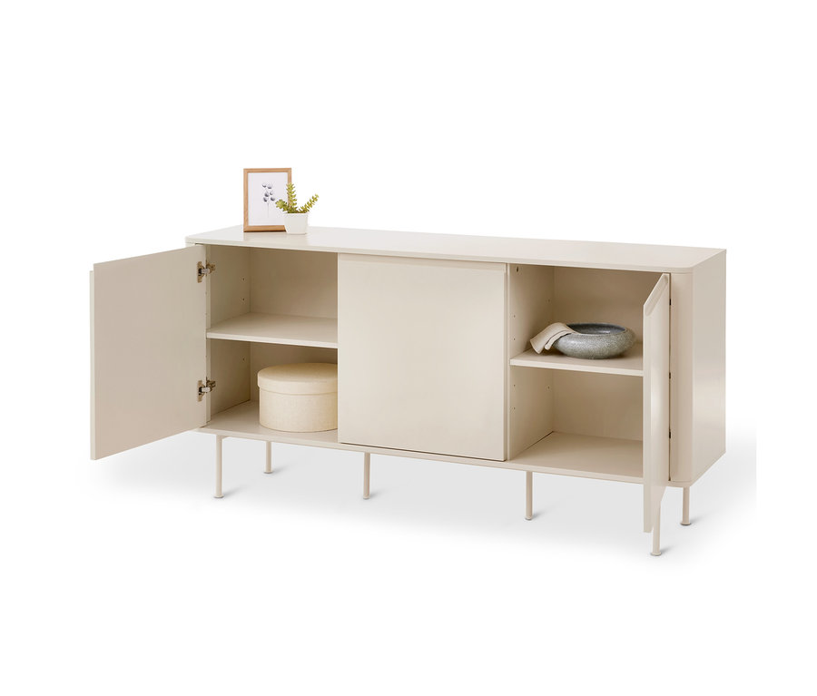 Helles beiges Sideboard mit vier Beinen und drei Fächern. Oben stehen ein kleiner Bilderrahmen und eine Topfpflanze. Die linke Tür ist offen und zeigt zwei Regalböden mit einer runden Schachtel unten. Das mittlere Fach hat eine geschlossene Schiebetür. Die rechte Tür ist offen und zeigt zwei Regalböden mit einer grauen Schale und einem Tuch oben.