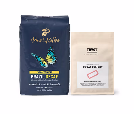 Zwei Kaffeepackungen: Links blaue Packung „Privat Kaffee Brazil Decaf“, rechts helle Packung „Tryst Decaf Delight“.