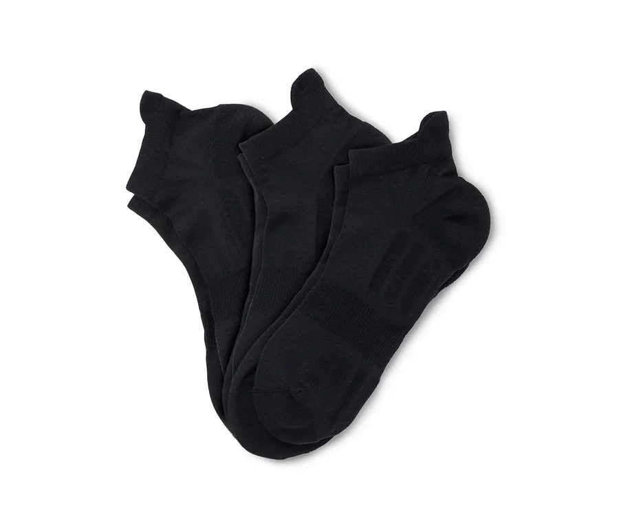 Drei schwarze Knöchelsocken liegen ordentlich gefaltet auf einem weißen Hintergrund.