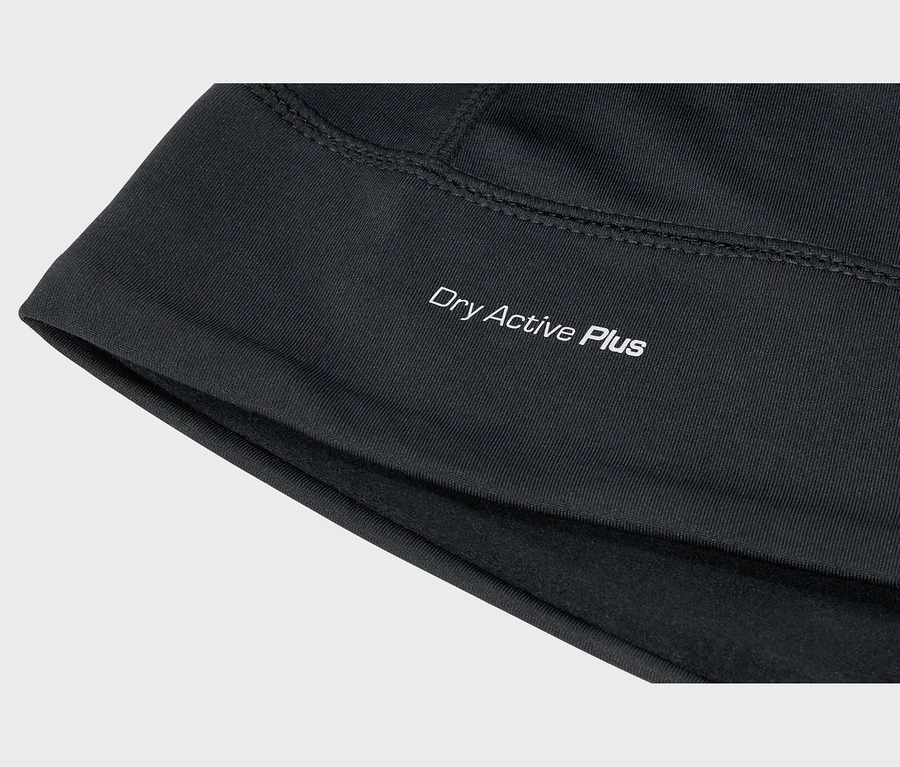 Nahaufnahme von schwarzem Stoff mit weißem „Dry Active Plus“-Aufdruck, sichtbaren Nähten und weichem Innenfutter.