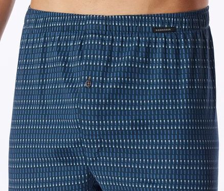 Dunkelblaue Herren-Boxershorts mit elastischem Bund und einem Muster aus kurzen, blauen und weißen Strichen. Ein Knopfverschluss ist sichtbar, und der Markenname SCHIESSER ist auf dem Bund zu sehen.