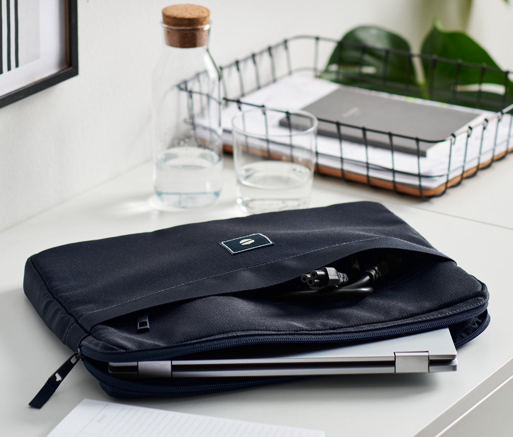 Auf einem weißen Tisch liegt eine blaue Laptoptasche.