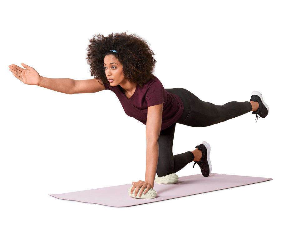 Frau macht eine Balanceübung mit 2 Balance-und-Massage-Pads.