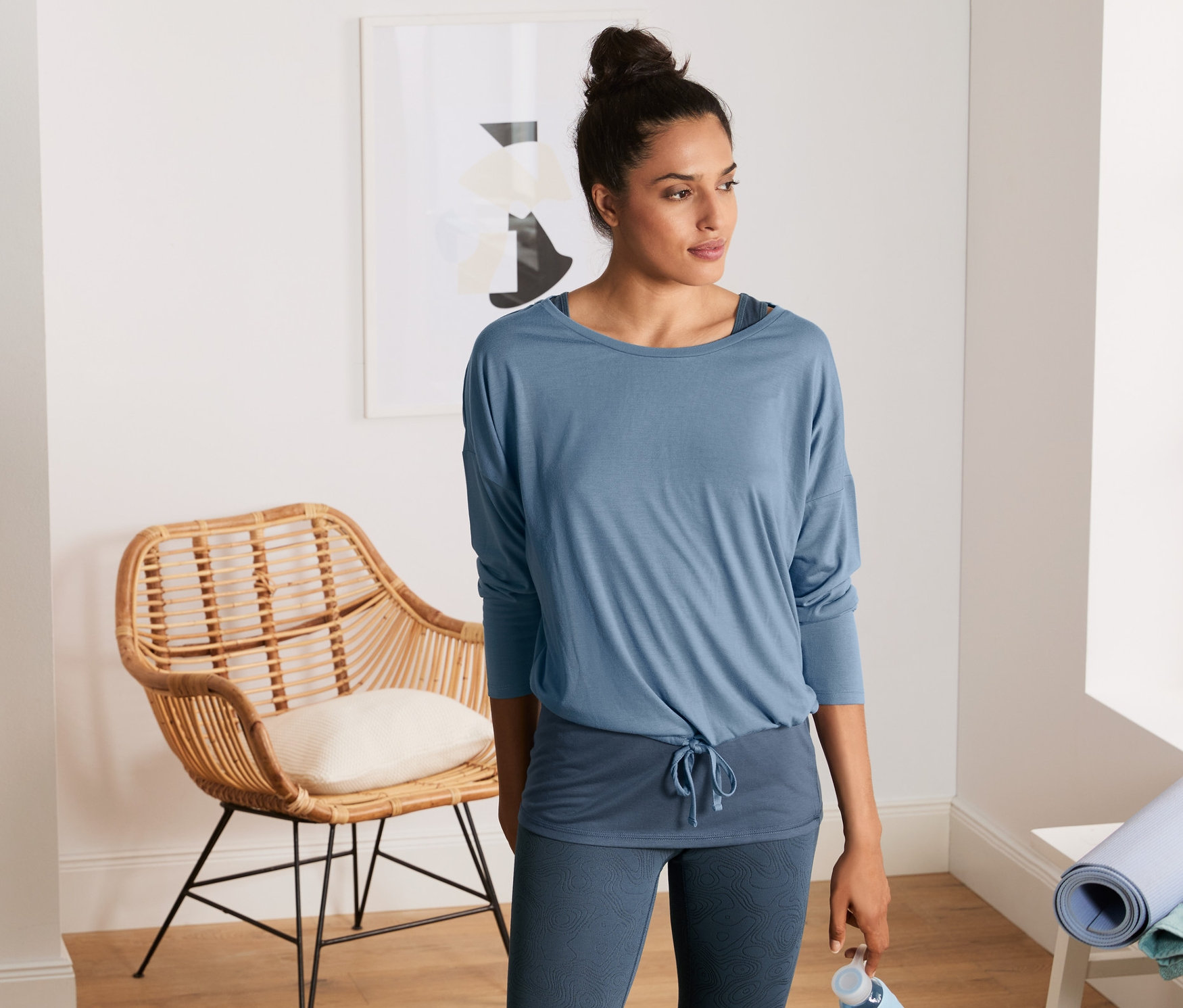 Frau mit einem blauen 2-in-1-Sportshirt.