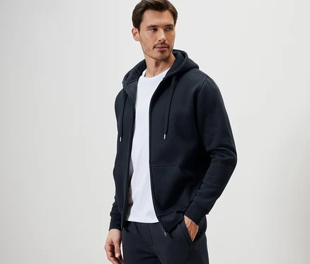 Mann trägt eine Kapuzenjacke und ein weißes T-Shirt.