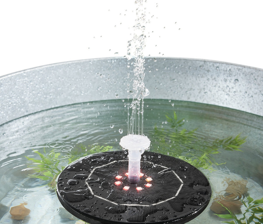 Schwimmender Solar-Springbrunnen mit Beleuchtung spritzt Wasser in einem Metalleimer.