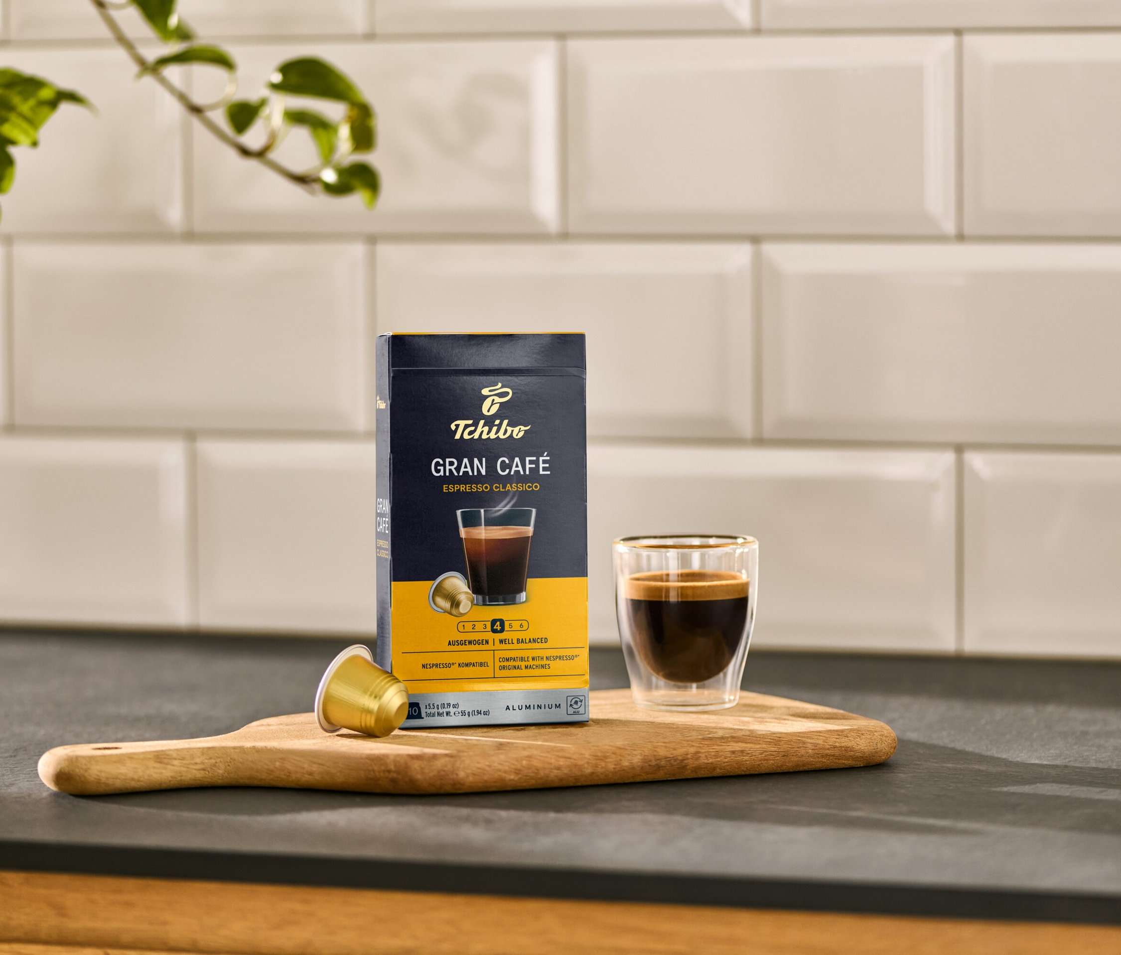 Eine Packung und eine Tasse Gran Café Espresso Classico stehen auf einem Holzbrett.