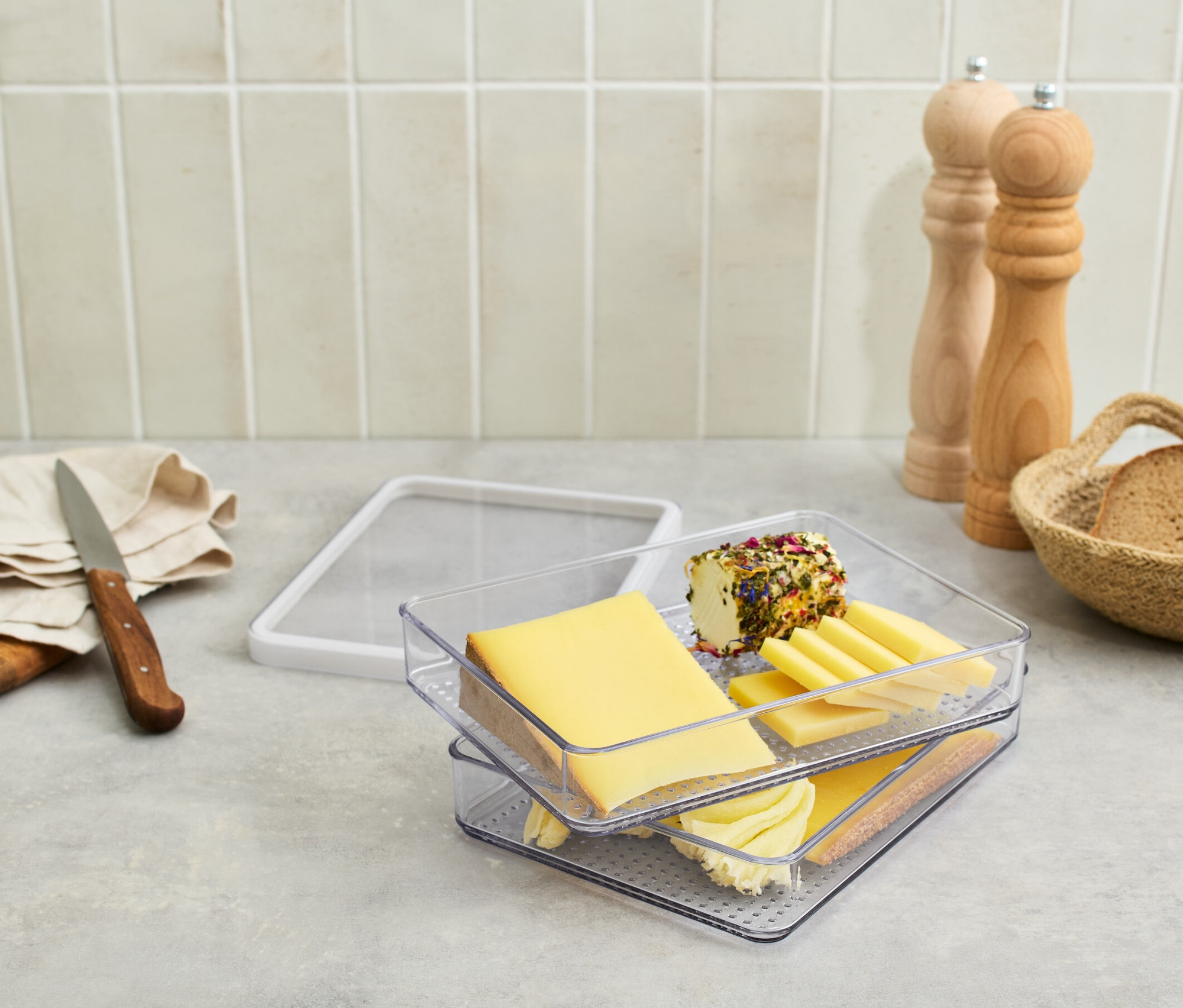 Aufschnittbox mit Käse und Wurst auf einem Tisch.