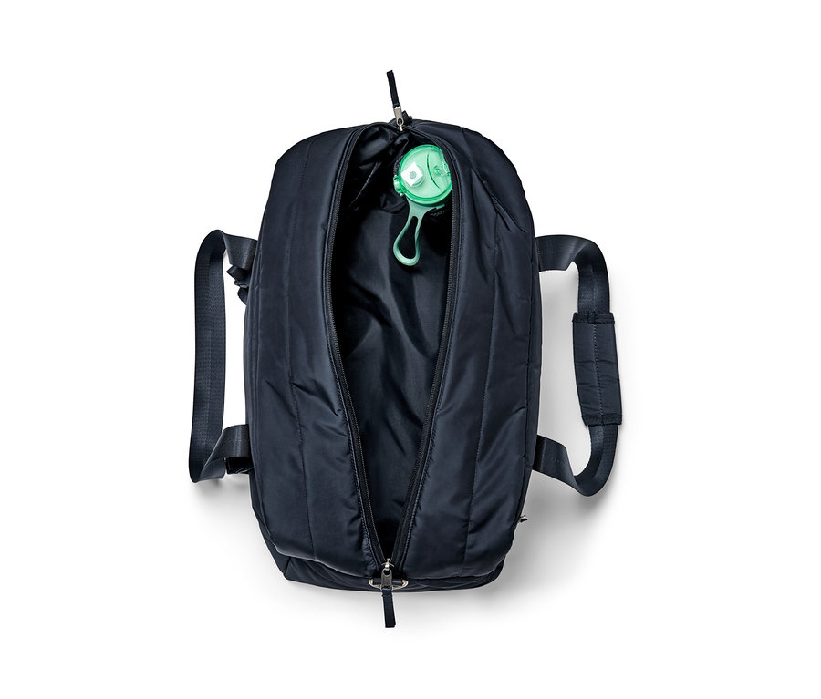 Offene schwarze Sporttasche mit einer grünen Wasserflasche darin.
