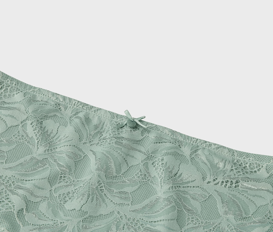 Detailaufnahme hellgrüner Spitze mit Schleife.