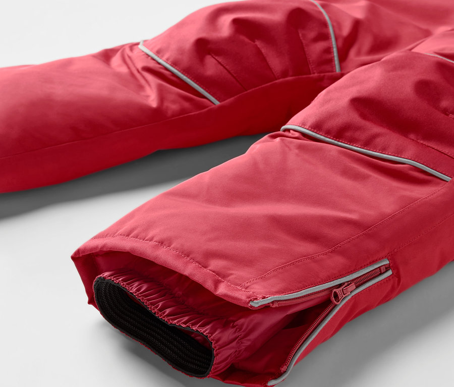Detail einer roten Skihose mit Reißverschluss am Bein.