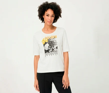 Frau trägt ein weißes Olsen 3/4-Shirt mit Blumenmuster und schwarzer Hose.